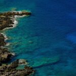 francesco-ungaro Costa rocciosa con mare turchese, esempio di paesaggio geologico