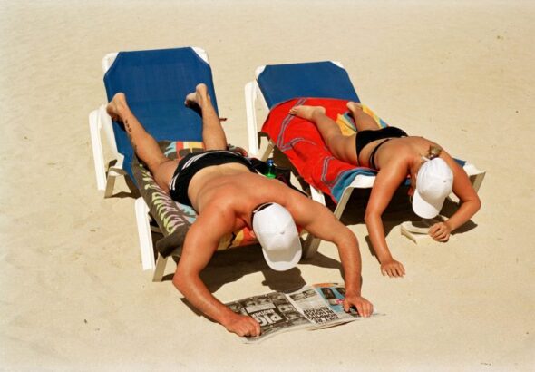 Martin-Parr_Prendendo-il-sole-e-leggendo-sulla-spiaggia_Magaluf_Maiorca_Spagna-2003-©Martin-Parr_Magnum-Photos-768x514
